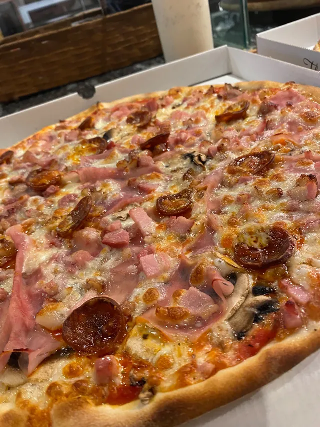 Una pizza recién hecha en su caja